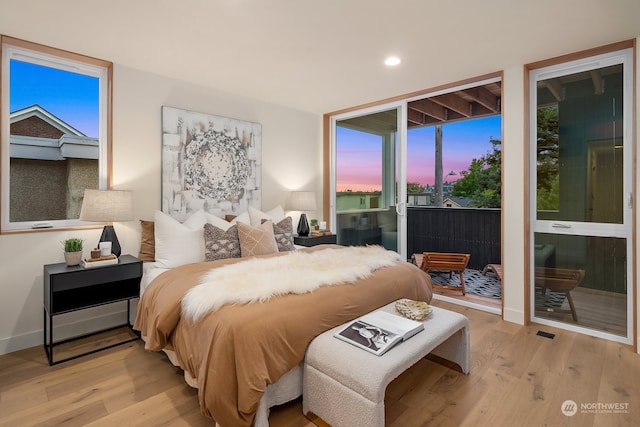 bedroom with access to exterior and light hardwood / wood-style floors