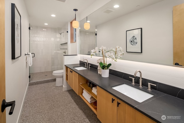 bathroom featuring vanity, a shower with shower door, and toilet