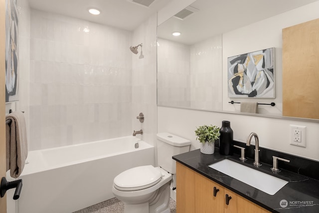 full bathroom with vanity, tiled shower / bath combo, and toilet