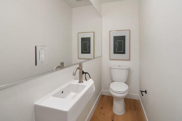 bathroom featuring hardwood / wood-style flooring, toilet, and sink