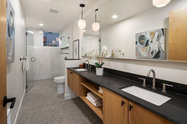 bathroom with vanity, a shower with door, and toilet