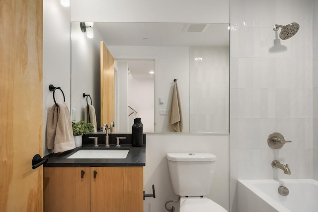 full bathroom with tiled shower / bath, vanity, and toilet