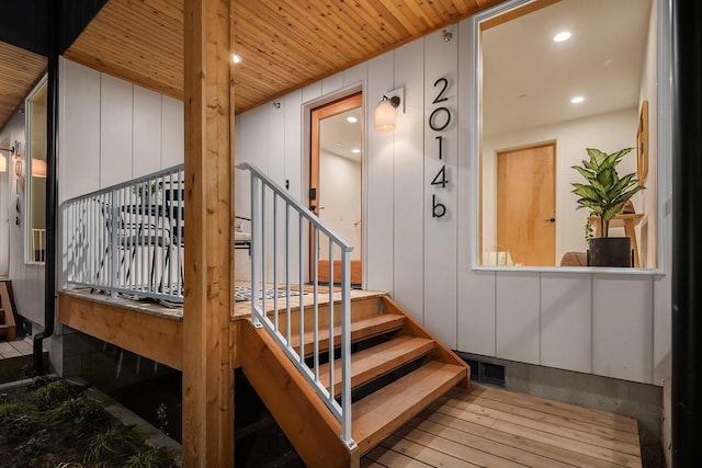 stairway with hardwood / wood-style flooring and wooden ceiling