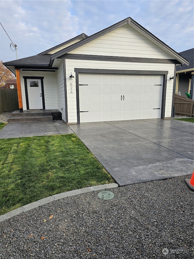 ranch-style home with a garage and a front lawn