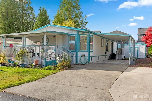 manufactured / mobile home featuring covered porch and a carport