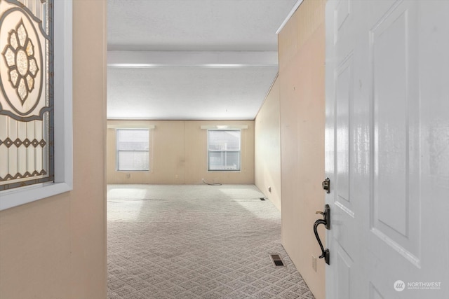 carpeted spare room with a textured ceiling