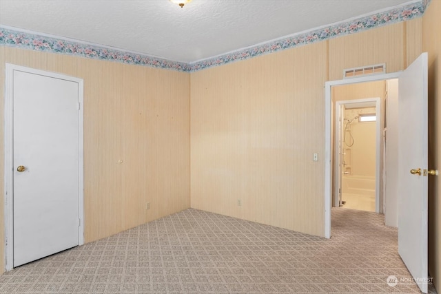 carpeted spare room featuring a textured ceiling