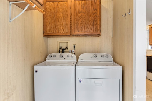 laundry room with separate washer and dryer and cabinets