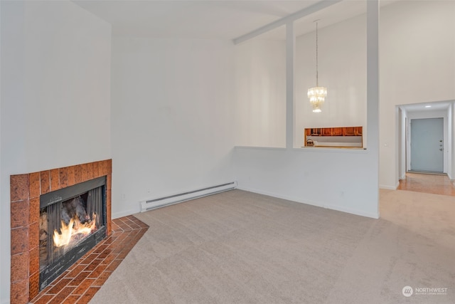 unfurnished living room with a baseboard radiator, high vaulted ceiling, a tile fireplace, and carpet floors