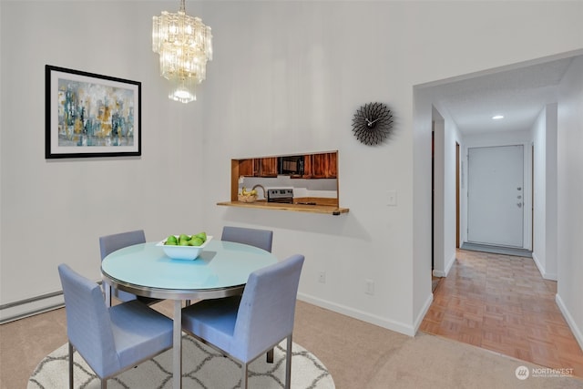 dining room with light parquet floors, a baseboard heating unit, and a notable chandelier