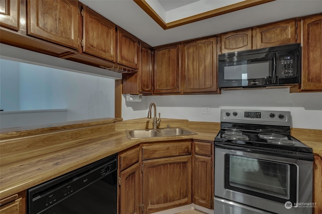 kitchen featuring butcher block countertops, sink, and black appliances