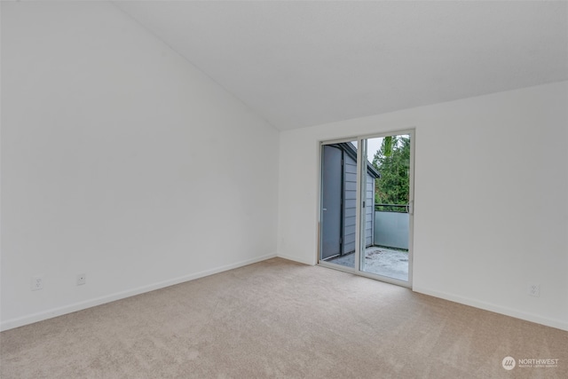 carpeted spare room with lofted ceiling