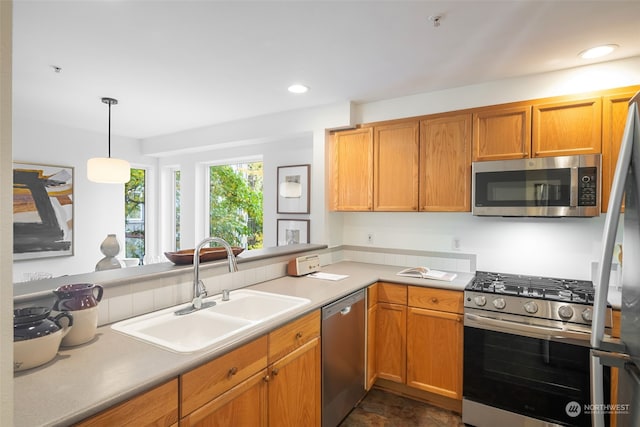 kitchen featuring sink, decorative light fixtures, and appliances with stainless steel finishes