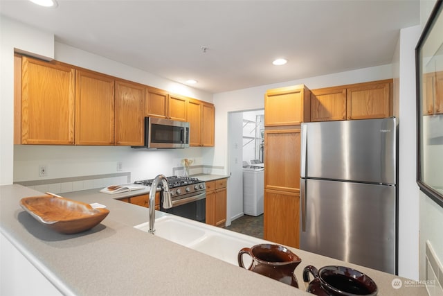 kitchen with washing machine and dryer and stainless steel appliances