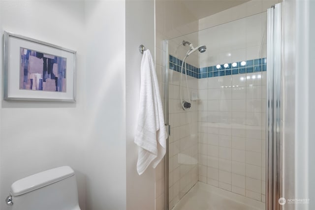 bathroom with toilet and a tile shower