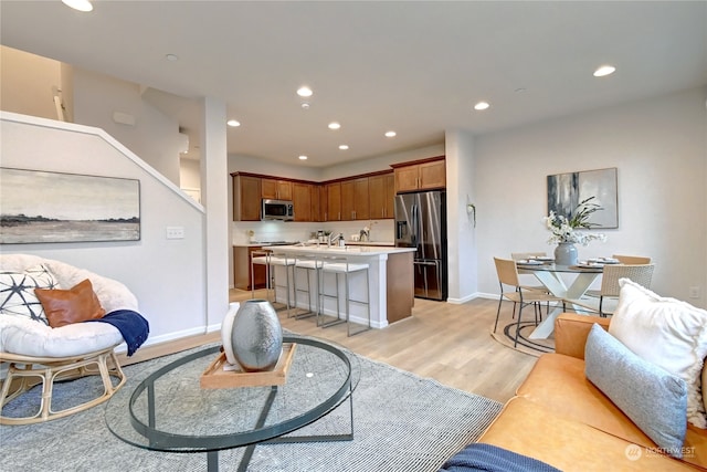 living room featuring light wood-type flooring and sink