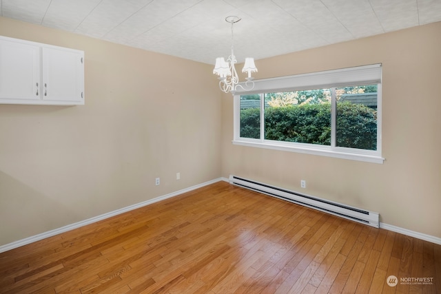 unfurnished dining area with a notable chandelier, light hardwood / wood-style floors, and baseboard heating