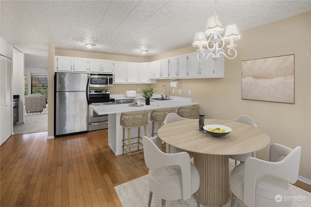 dining area with dark hardwood / wood-style flooring, an inviting chandelier, and sink