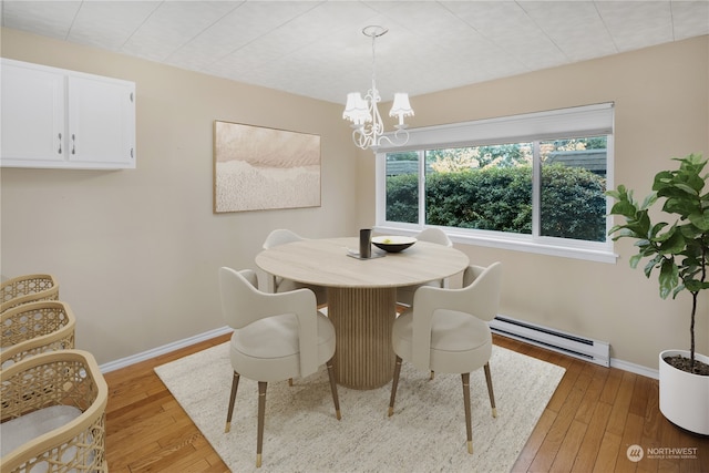 dining space with baseboard heating, light hardwood / wood-style floors, and a notable chandelier