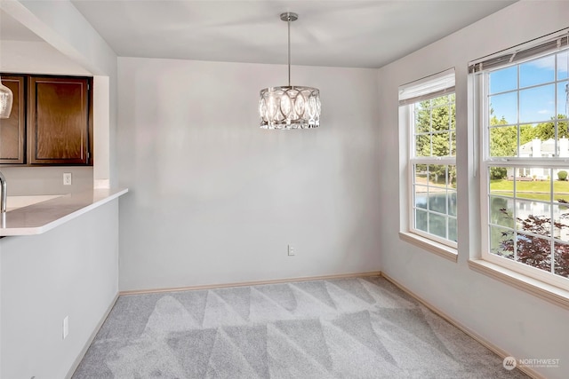 unfurnished dining area featuring light carpet and a notable chandelier