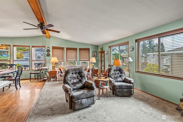 living room featuring vaulted ceiling with beams, ceiling fan, and wood-type flooring