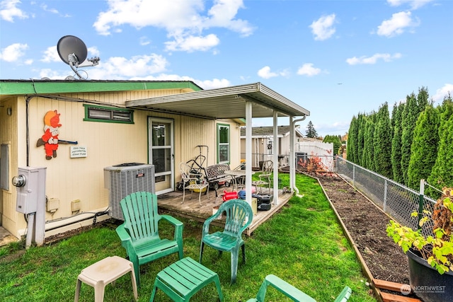 back of property featuring a yard and central AC