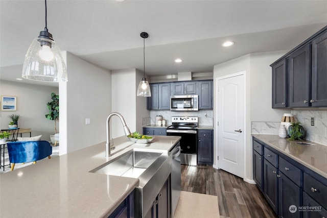 kitchen featuring decorative backsplash, appliances with stainless steel finishes, hanging light fixtures, and dark wood-type flooring