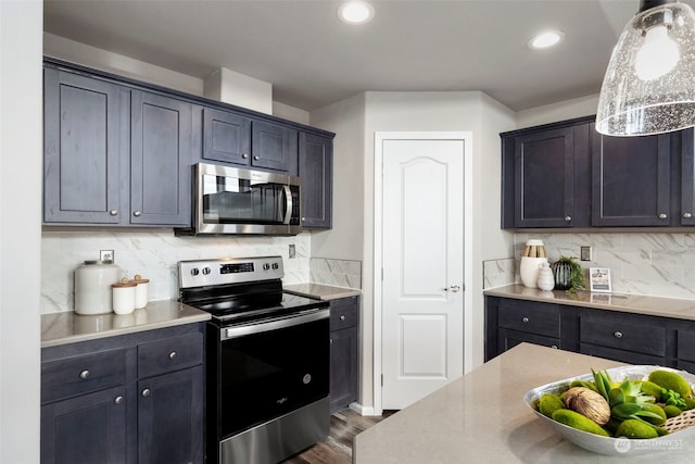 kitchen with backsplash, dark hardwood / wood-style flooring, stainless steel appliances, and hanging light fixtures