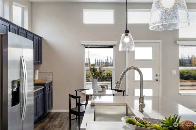 kitchen featuring a wealth of natural light, pendant lighting, dark wood-type flooring, and stainless steel refrigerator with ice dispenser