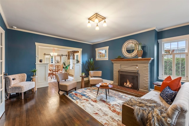 living room featuring a brick fireplace, dark hardwood / wood-style floors, and crown molding