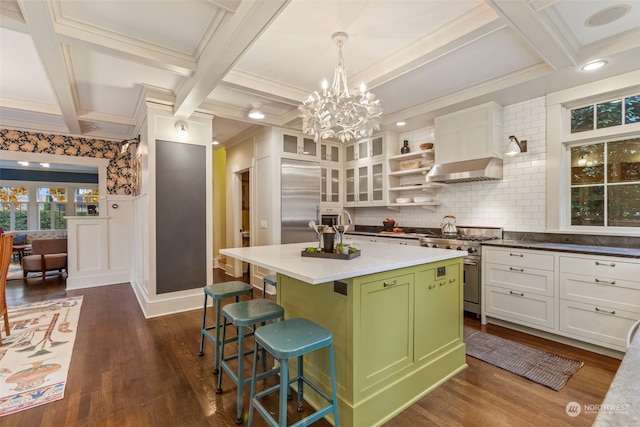 kitchen featuring dark hardwood / wood-style floors, pendant lighting, a kitchen breakfast bar, high end appliances, and a kitchen island with sink