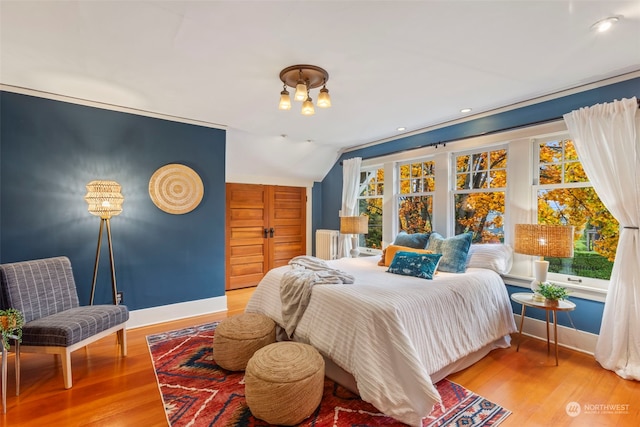 bedroom featuring light hardwood / wood-style floors and lofted ceiling