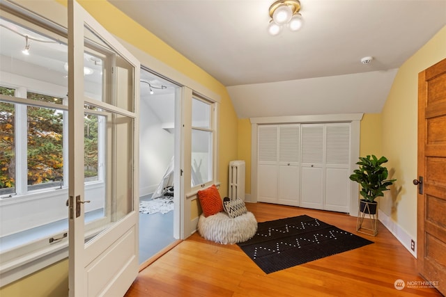 2033 11th Ave E, Seattle, WA 98102 - entryway featuring french doors, light wood-style floors, lofted ceiling, radiator, and baseboards