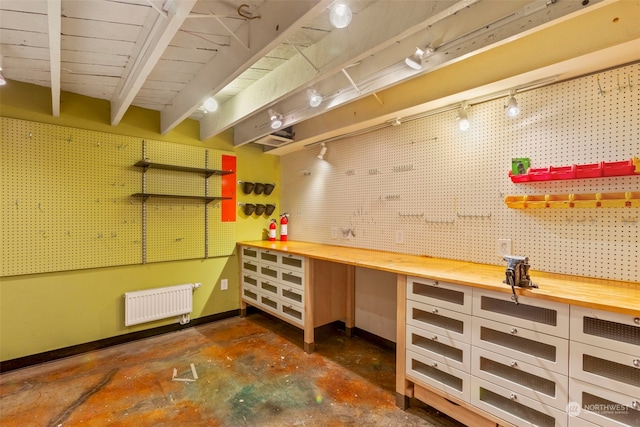 2033 11th Ave E, Seattle, WA 98102 - miscellaneous room with a workshop area, radiator heating unit, concrete flooring, baseboards, and beam ceiling