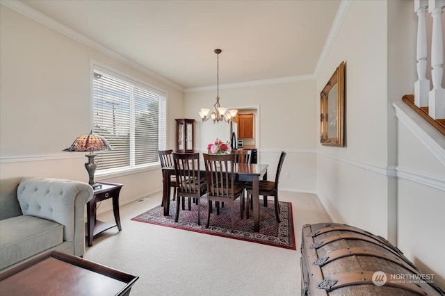 carpeted dining room with ornamental molding and an inviting chandelier