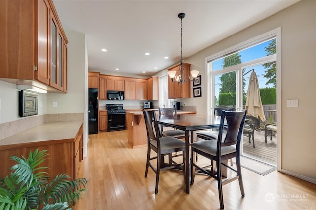 dining area featuring an inviting chandelier and light hardwood / wood-style flooring