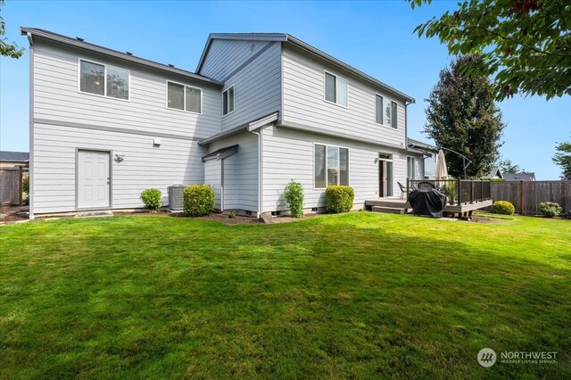 rear view of property with a lawn and central AC