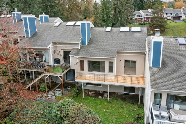 back of property featuring stairway, roof with shingles, and a chimney