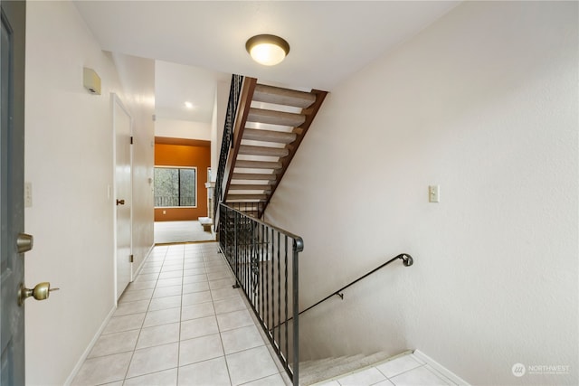 stairway featuring baseboards and tile patterned floors