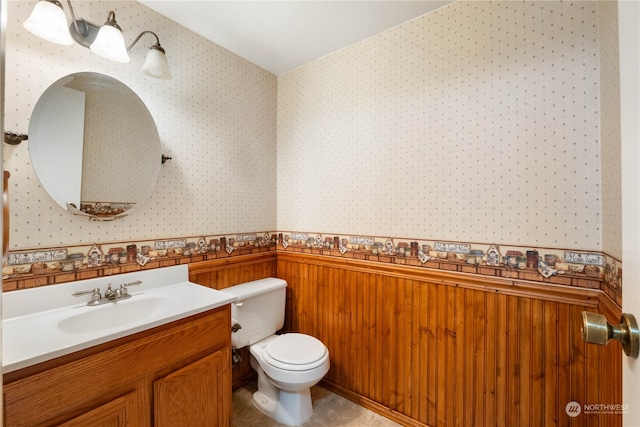 bathroom with tile patterned floors, vanity, toilet, and wallpapered walls