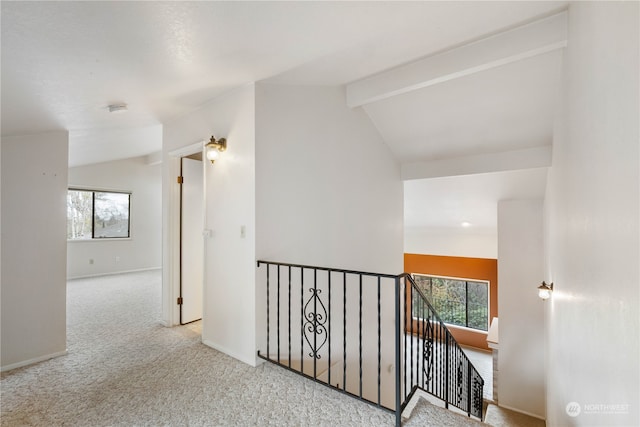 hall with lofted ceiling with beams, carpet, an upstairs landing, and a wealth of natural light