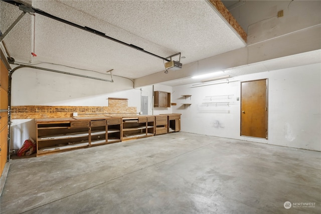 garage with electric panel and a garage door opener