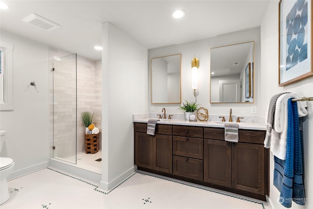 bathroom featuring a tile shower, vanity, and toilet