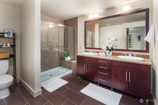 bathroom with vanity, a shower with door, tile patterned flooring, and toilet