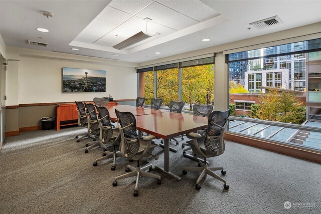 carpeted home office with a tray ceiling