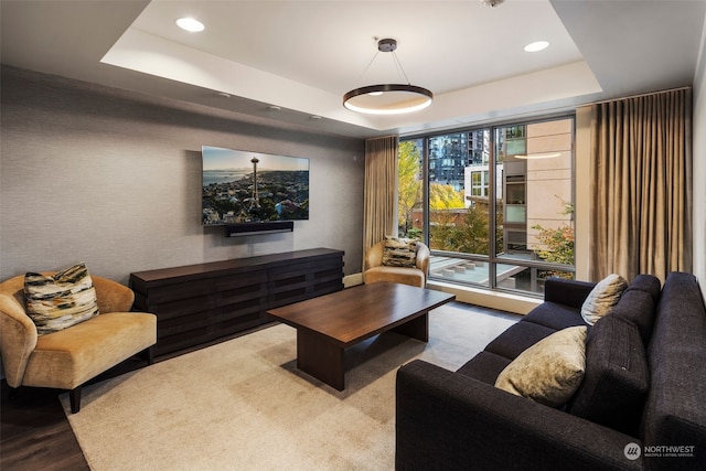 living room featuring a raised ceiling and light wood-type flooring