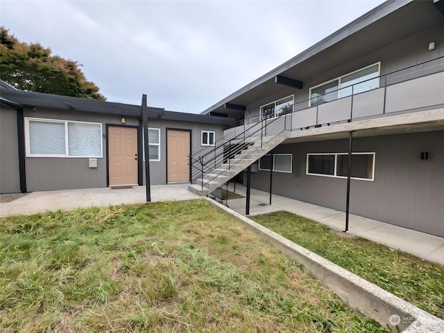 back of house featuring a lawn and a patio