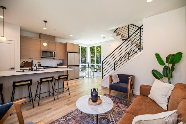 living room with sink and light hardwood / wood-style floors