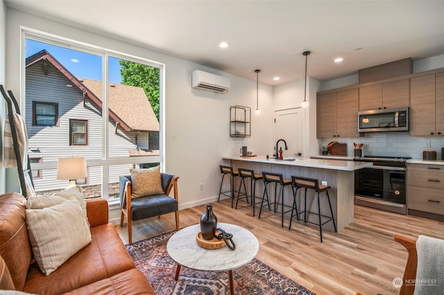 living room with light wood-type flooring, sink, and an AC wall unit