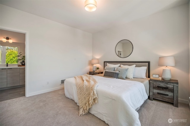 carpeted bedroom featuring ensuite bathroom